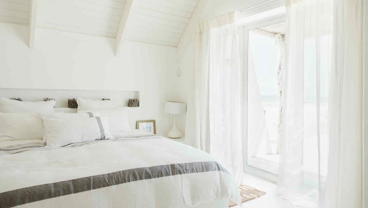 Dormitorio con cortinas blancas